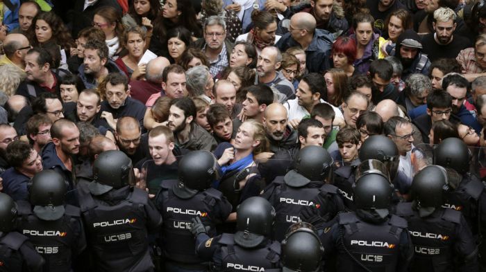 La Policía Nacional trata de evitar que los votantes entre en el colegio electoral.